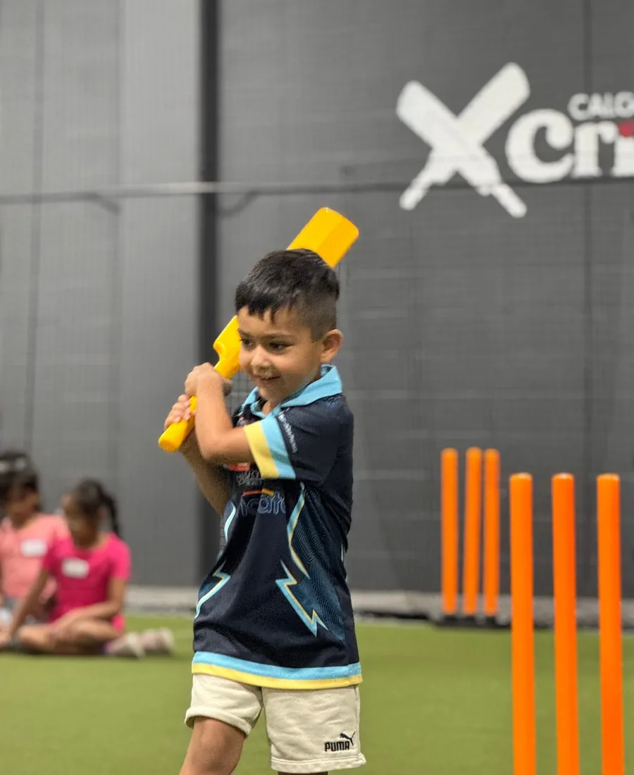 A young batter lining up a shot in the indoor nets